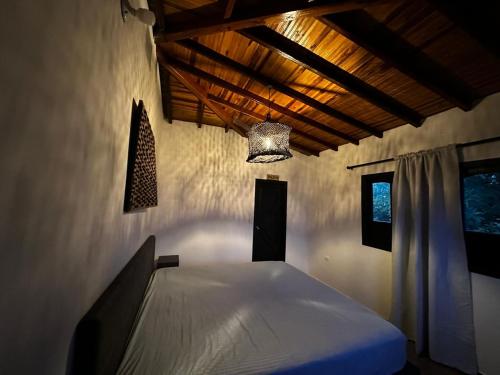 a bedroom with a white bed in a room at El Nido de Fenix in Aratoca