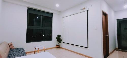 a white room with a large window and a couch at Bcons Garden Luxury Aparment in Dĩ An