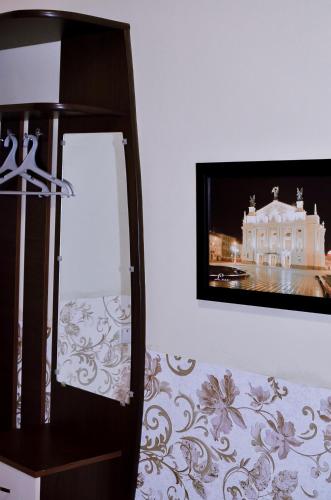 a tv on a wall next to a room at Guest House Mandrivnyi Rooms&Apartments in Yasinya