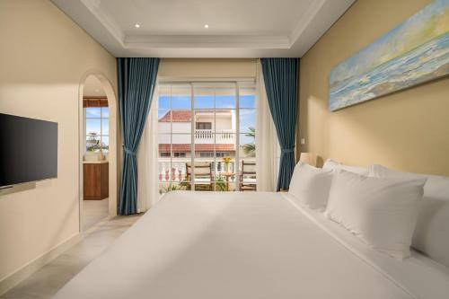a bedroom with a large bed and a large window at Spring Breeze Hotel Hoi An in Hoi An