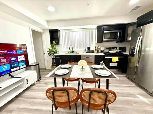 a kitchen with a table and chairs and a television at GilmoreOne in Van Nuys