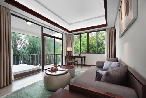 a living room with a couch and a large window at 广悦华阳朔河畔酒店 in Gaotian