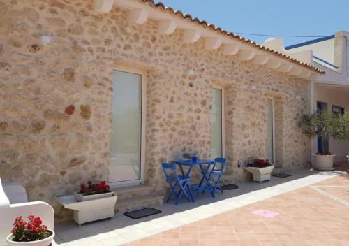 a patio with blue chairs and a stone wall at Casa Vacanze Brezza di Gaffe in Torre di Gaffe