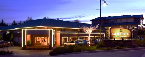 a building with a car parked in a parking lot at Gibsons Garden Hotel in Gibsons