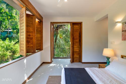 a bedroom with a bed and a large window at Paradise Itzu in Kandy