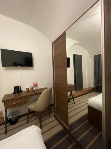 a hotel room with a desk and a bedroom at Hotel Casa Andalucia in Hallbergmoos