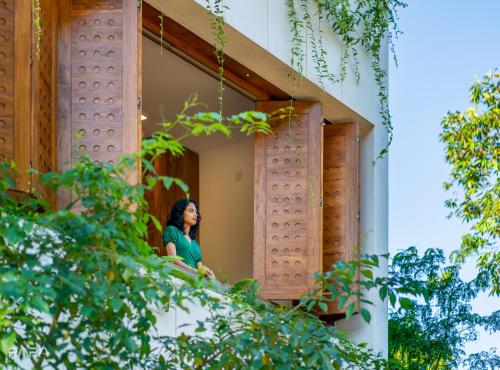 a woman looking out of a window of a building at Paradise Itzu in Kandy