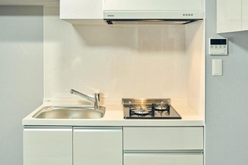 a kitchen with a sink and a stove at Vacation Rental Hotel TENMONKAN in Kagoshima