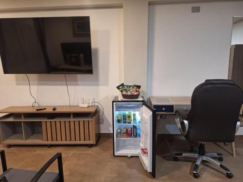 frigorifero in un ufficio con scrivania e sedia di Hotel MAXIMUM COMFORT FCA a Salinas