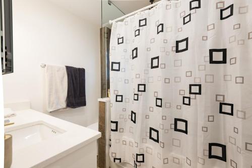 a bathroom with a shower curtain and a sink at Beautiful Vancouver Cedar Cottage House in Vancouver