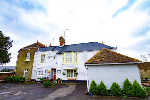 a man standing on the roof of a white house at The Beaumont in Sittingbourne