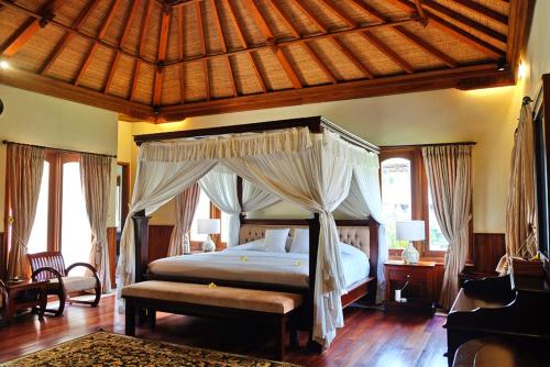a bedroom with a bed with a canopy at Bagus Jati Health & Wellbeing Retreat in Tegalalang