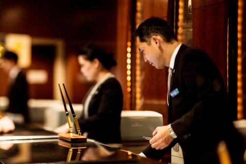 a man in a suit looking at his cell phone at InterContinental Halong Bay Resort by IHG in Ha Long