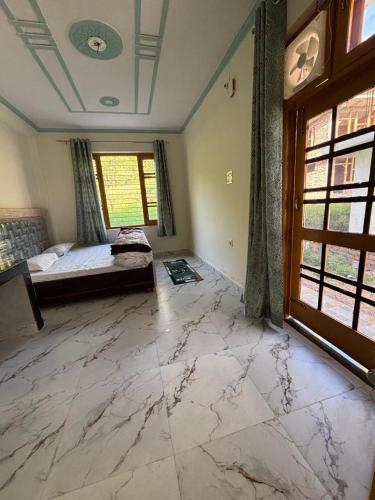 a large room with a marble floor and a bedroom at Tranquil trails home stay naddi in Dharamshala