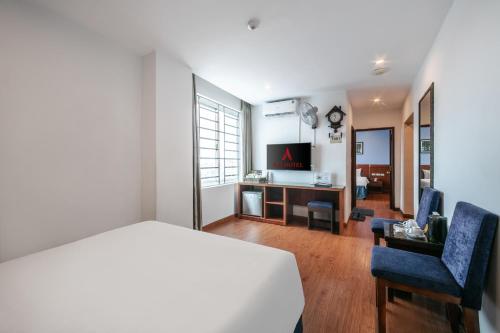 a bedroom with a bed and two chairs and a television at A25 Hotel - 63A Phương Liệt in Hanoi