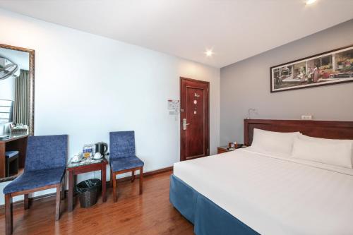 a bedroom with a bed and two blue chairs at A25 Hotel - 63A Phương Liệt in Hanoi