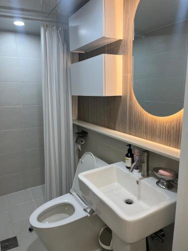 a bathroom with a sink and a toilet and a mirror at Cozy 3-4 person accommodation in Suwon