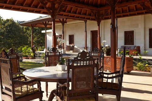 a patio with a table and chairs and a house at Bagus Jati Health & Wellbeing Retreat in Tegalalang