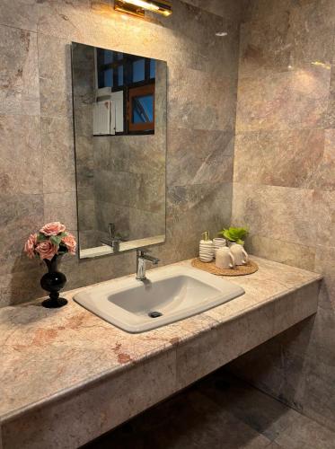 a bathroom counter with a sink and a mirror at Full House Chiang Mai in Chiang Mai