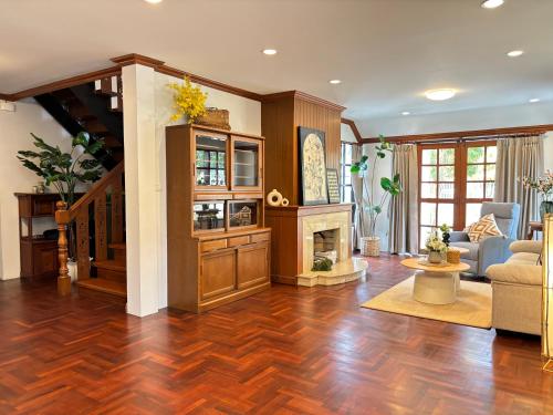 a living room with wood floors and a fireplace at Full House Chiang Mai in Chiang Mai
