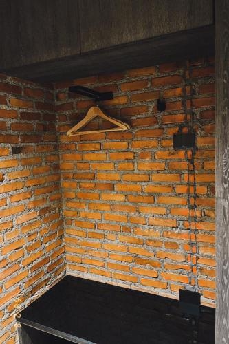 a brick wall with a wooden hanger on it at Santisookmidtown Pattani in Kampong Rusamileh