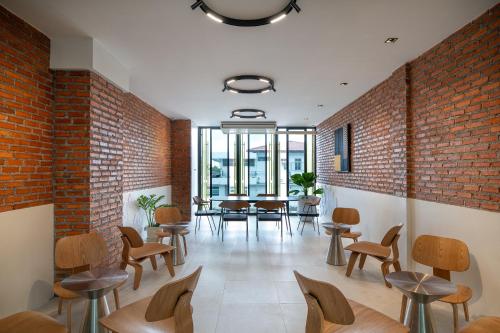 a room with chairs and tables and a brick wall at Santisookmidtown Pattani in Kampong Rusamileh