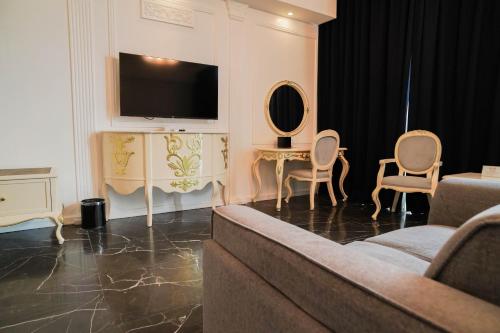 a living room with a couch and a tv and chairs at Sunday Hevea Hotel and Resort in Angeles