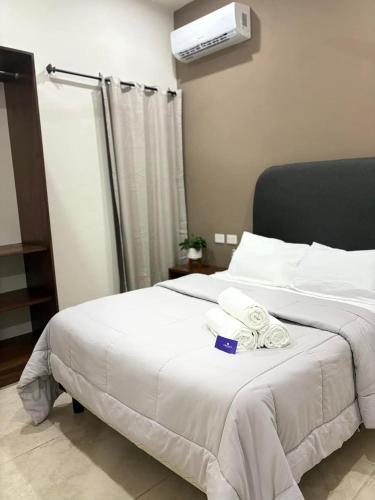 a bedroom with a large white bed with towels on it at Hotel and Suites Hortensias in Tapachula