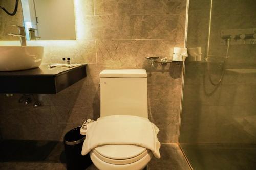 a bathroom with a toilet and a sink at Sunday Hevea Hotel and Resort in Angeles