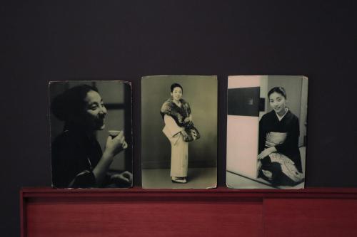 four pictures of women on a wooden shelf at Ito Ryokan in Tokyo