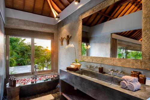 a bathroom with a large tub and a large window at Ipanema Villa Bali in Canggu