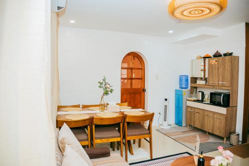 a dining room with a table and a kitchen at Love, Lourdes Villa in Imus