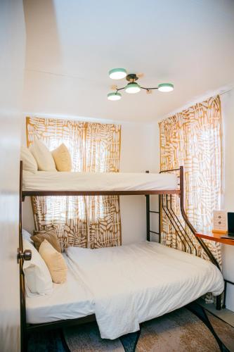 two bunk beds in a room with a window at Love, Lourdes Villa in Imus