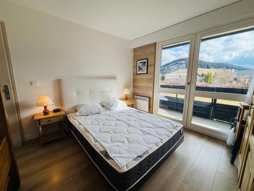 オトゥランにあるAppartement rénové à Autrans, idéal pour nature et randonnées - FR-1-737-97の大きなベッドと大きな窓のある寝室