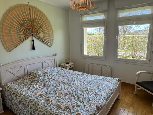 - une chambre avec un lit et un grand ventilateur mural dans l'établissement Charmant 3 pièces avec terrasse près de la plage et parking sécurisé - FR-1-487-379, à Cabourg