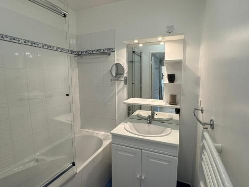une salle de bain blanche avec un lavabo et une douche dans l'établissement Charmant 3 pièces avec terrasse près de la plage et parking sécurisé - FR-1-487-379, à Cabourg