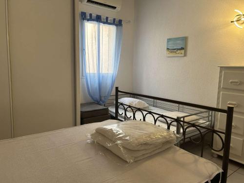 une chambre avec deux lits superposés et une fenêtre dans l'établissement Maison 2 pièces mezzanine à Saint Pierre la Mer, terrasse et parking privé - FR-1-229D-154, à Fleury