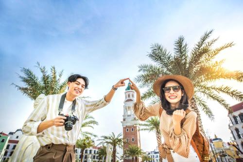 two people posing for a picture in front of a clock tower at Vinholidays Fiesta Phu Quoc in Phu Quoc