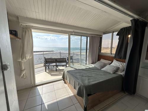 une chambre avec un lit et une vue sur l'océan dans l'établissement Le Grau d'Agde - Studio confortable pour 4 personnes - FR-1-249-425, au Grau-dʼAgde