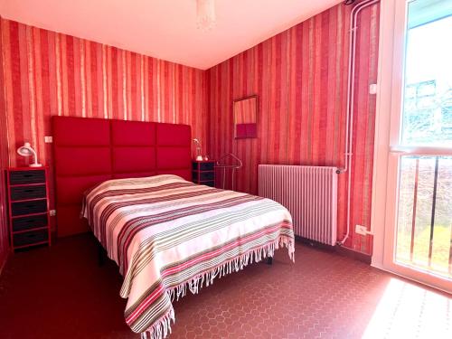 - une chambre rouge avec un lit et une fenêtre dans l'établissement Appartement T2 Saint-Cyprien près du port avec parking - FR-1-309-500, à Saint-Cyprien
