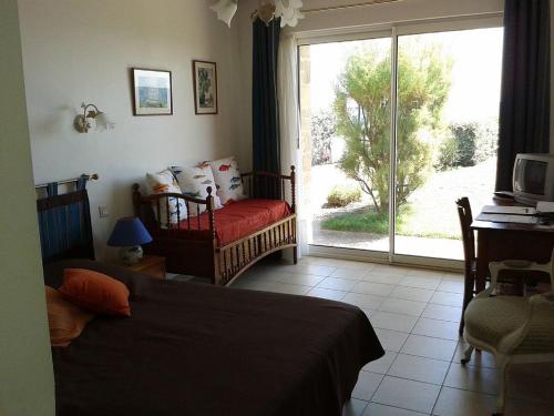 une chambre avec un lit et une porte coulissante en verre dans l'établissement Grande maison familiale à Sarzeau, 12 personnes, vue mer - FR-1-639-142, à Sarzeau