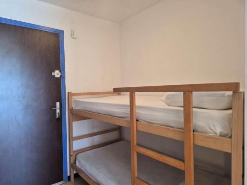 Cette chambre comprend 2 lits superposés et une porte. dans l'établissement Studio cabine 4 pers avec parking - Cap d'Agde - FR-1-249-426, au Cap d'Agde
