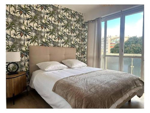 une chambre avec un grand lit avec une grande fenêtre dans l'établissement Appartement rénové à Juan les Pins avec parking - FR-1-252-198, à Antibes