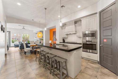 a kitchen with white cabinets and a kitchen island with bar stools at Best Day Ever townhouse in Washington