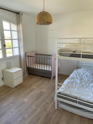 une chambre avec deux lits superposés et un plancher en bois dans l'établissement Maison au calme entre lac et bourg, à Biscarrosse