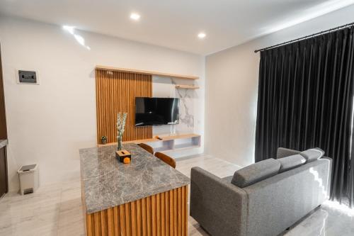 a living room with a couch and a television at Alyxia 1 Bedroom Apartment in Central Seminyak in Seminyak