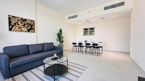 a living room with a blue couch and a table at Sunday Sheikh Zayed Road Concord Tower by Belvilla in Dubai