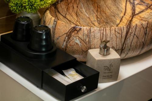 a black soap dispenser and a wooden bowl on a shelf at Westlake Pearl Suites & Spa 70 Xuan Dieu - By Pegasy Group in Hanoi