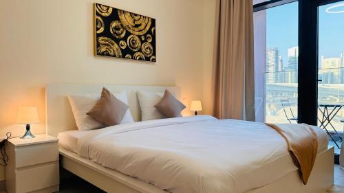 a bedroom with a white bed with a large window at Sunday Sheikh Zayed Road Concord Tower by Belvilla in Dubai