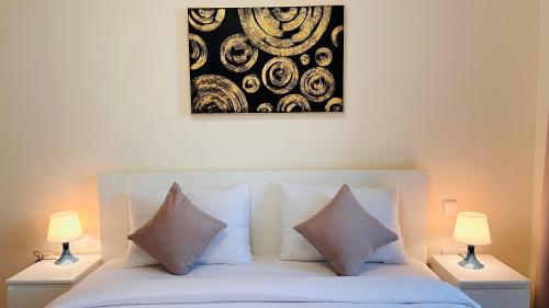 a bed with white pillows and a picture on the wall at Sunday Sheikh Zayed Road Concord Tower by Belvilla in Dubai